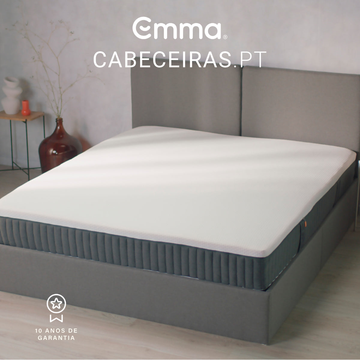 Colchão Emma Original Hybrid numa cama com cabeceira cinzenta