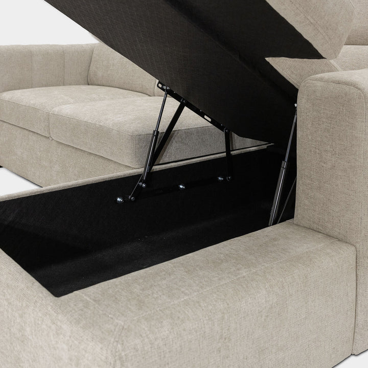 Sofá Gabi com chaise longue, arrumação elevatória e função sofá-cama, estofado em tecido bege de estilo contemporâneo.