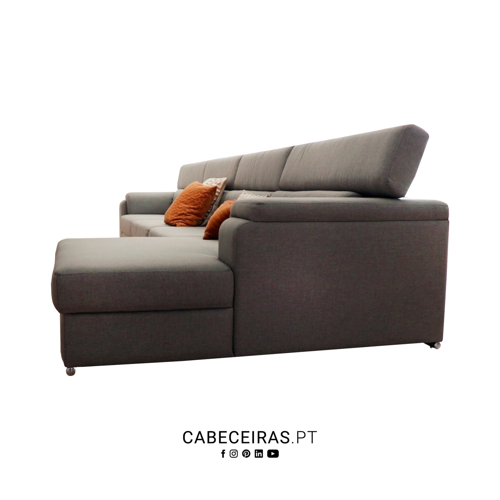 Sofá de canto cinzento com chaise longue à esquerda e almofadas decorativas laranja, em fundo branco.