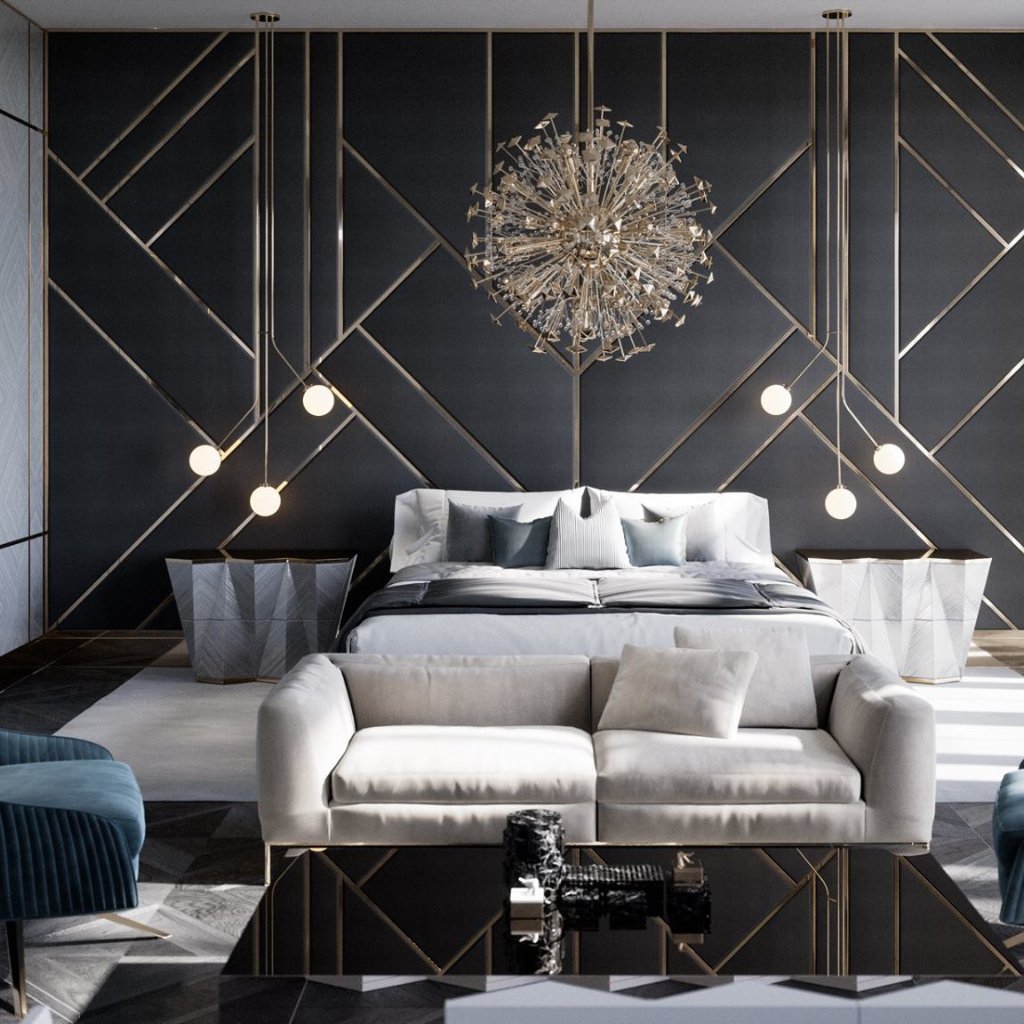 Quarto de luxo com cama, sofá bege, candeeiro de teto dourado e parede escura com painéis geométricos dourados.