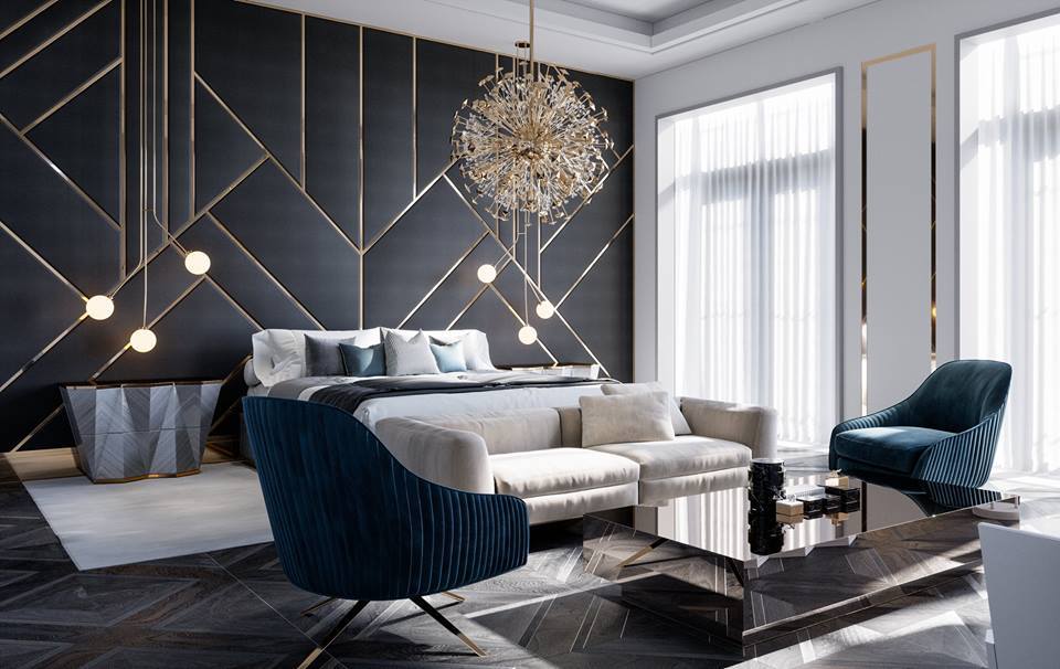 Quarto luxuoso com cama, cabeceira preta geométrica dourada, lustre dourado e candeeiros pendentes. Sofá bege, poltrona azul e mesa de centro.