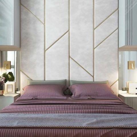 Quarto moderno com cabeceira estofada branca e linhas douradas geométricas, cama com roupa de cama roxa às riscas e manta cinzenta.