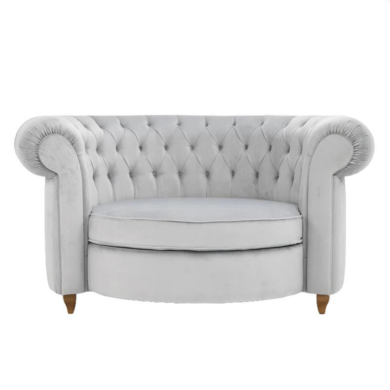 Poltrona Chesterfield cinzenta de veludo com encosto capitonê e braços enrolados, sobre fundo branco.