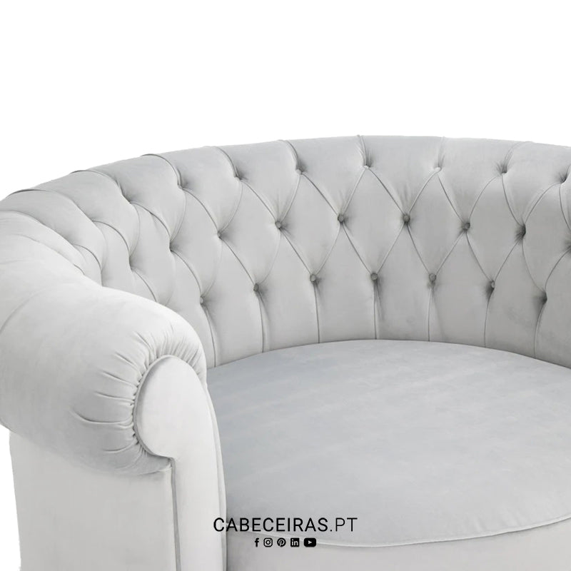 Poltrona de veludo cinzento claro com encosto capitonê e braço enrolado, da CABECEIRAS.PT.