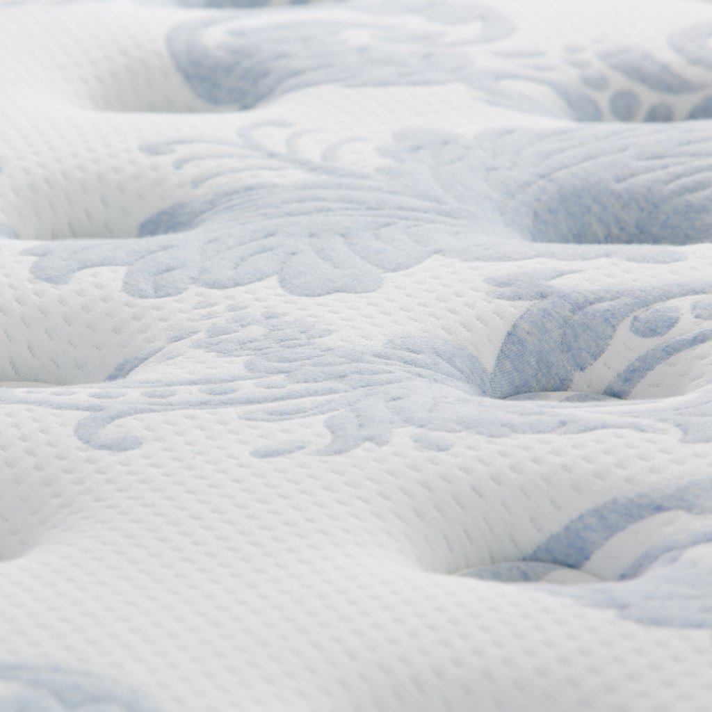 Superfície de colchão branco com padrão floral azul claro, textura suave e acolchoada.